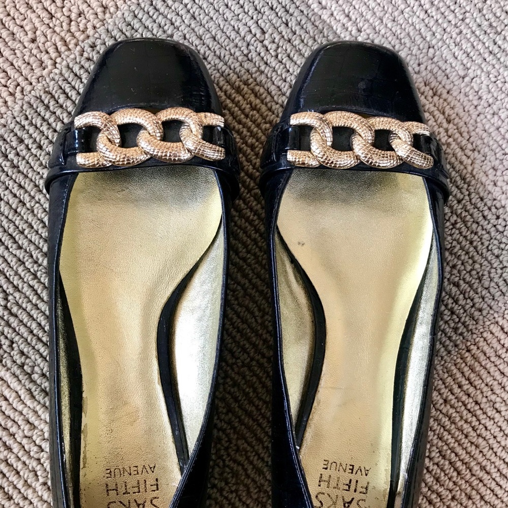 Black flats with gold chain on front